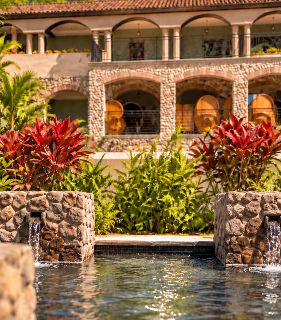 Stone arches, red plants and fountains in the courtyard